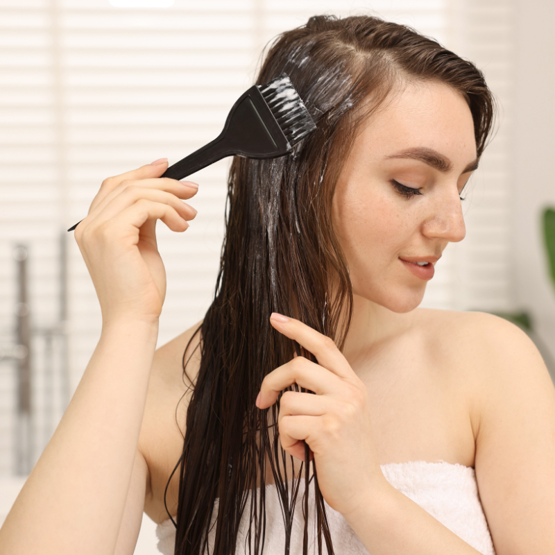 Woman applying herbal hair color